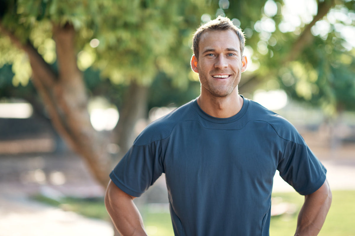 Why Do I Need a Multivitamin if I Already Have a Balanced Diet? Fit healthy man standing outside in sunshine