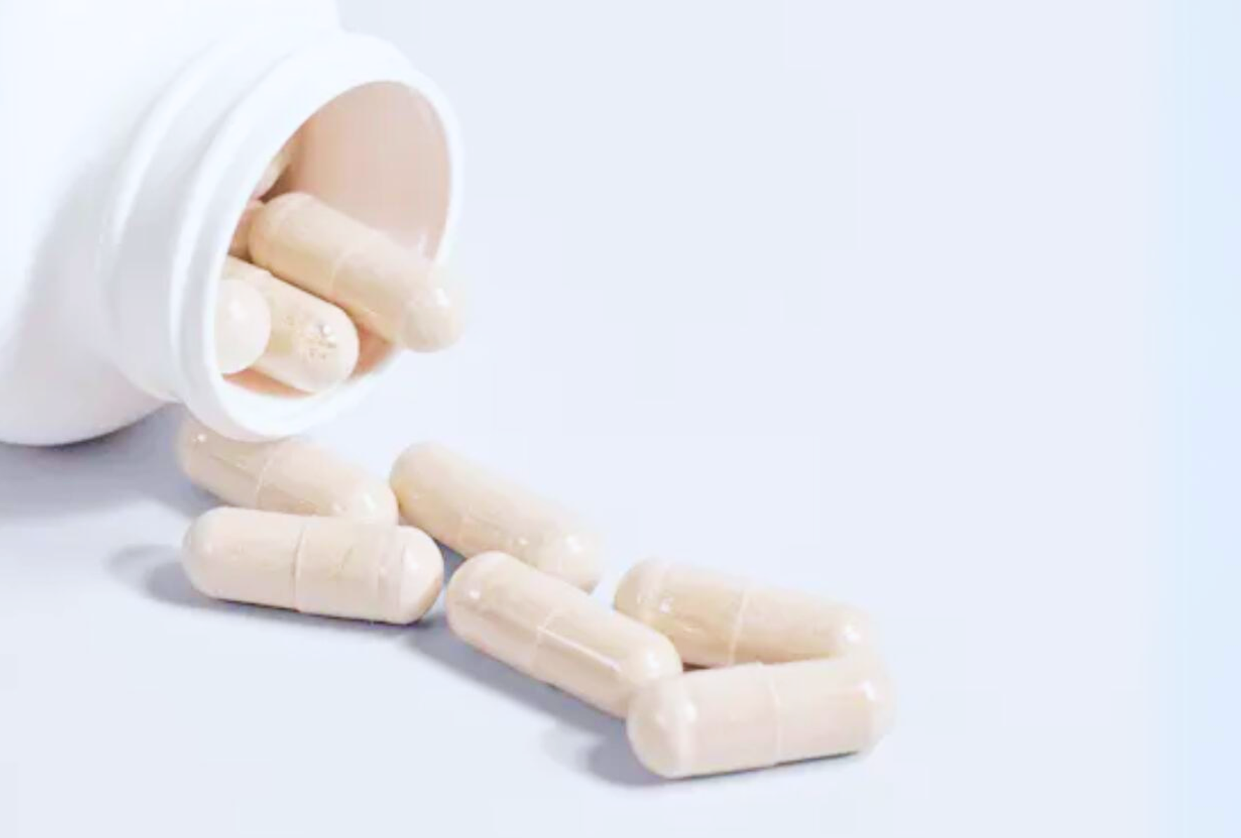 Skin multivitamin capsules on pale blue background