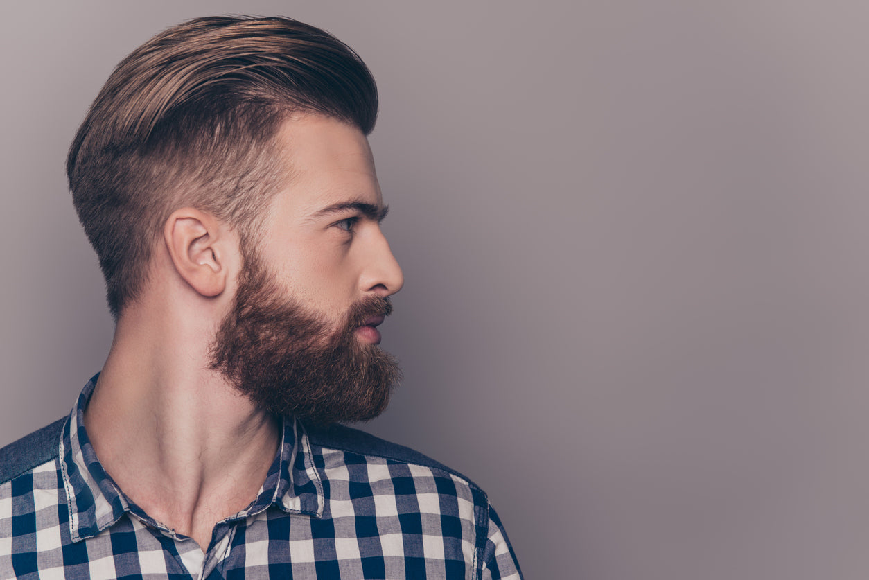 handsome man with a full, healthy beard. Viewed in profile