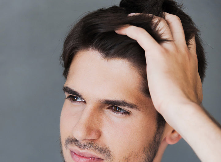 xx Best Vitamins for Hair Growth. Handsome young man runs his fingers through his hair
