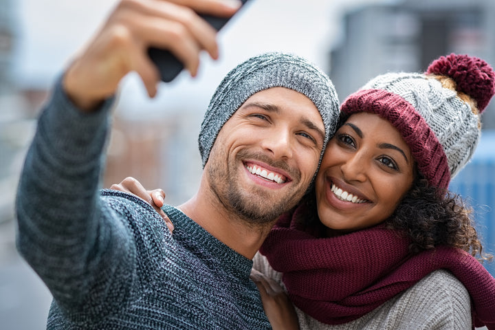 handsome young man and woman smiling and taking selfie photo