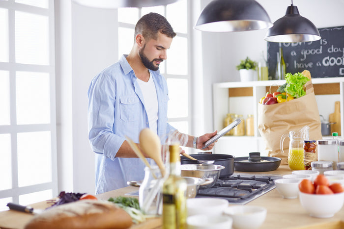 Handsome man cooking healthy food in large kitchen