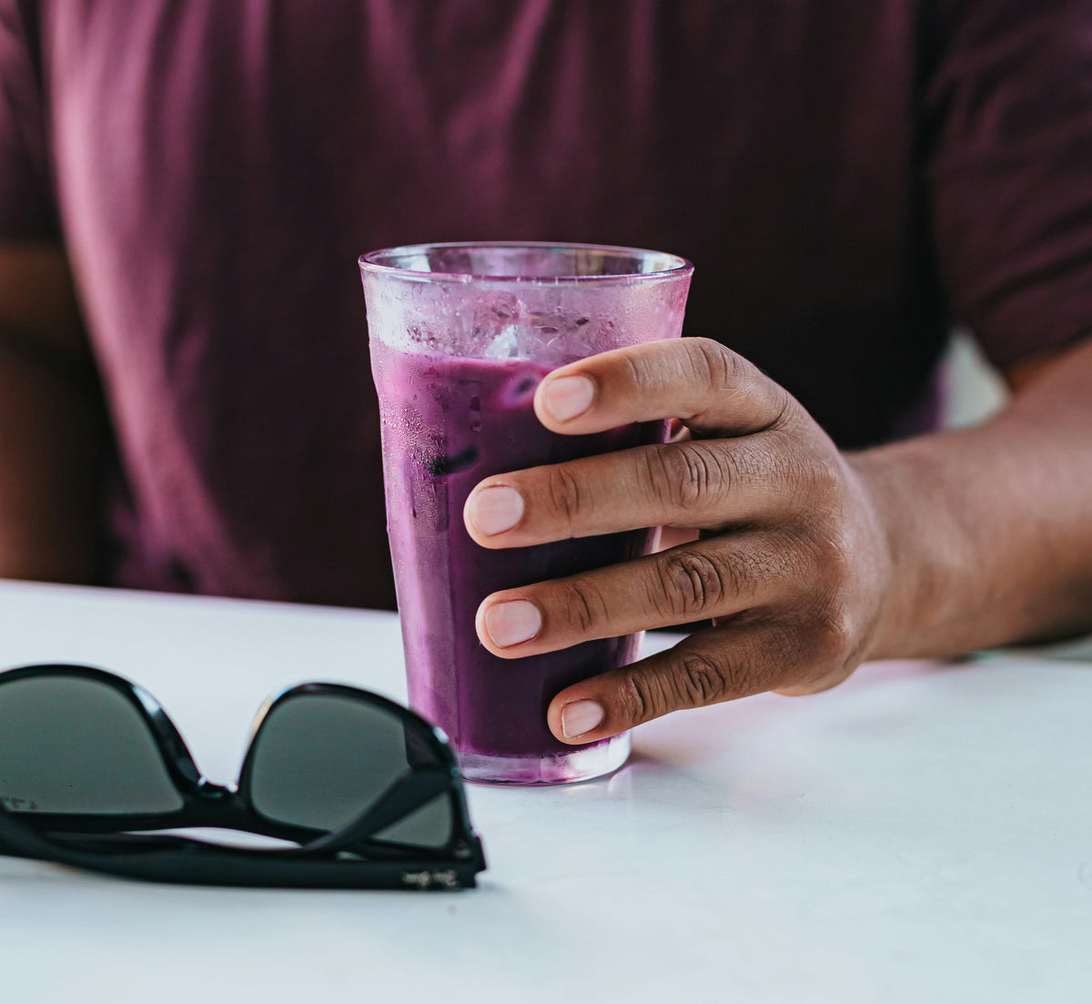 3 Antioxidant Smoothies for Brighter, More Resilient Skin. Man pouring healthy, green smoothie into glass