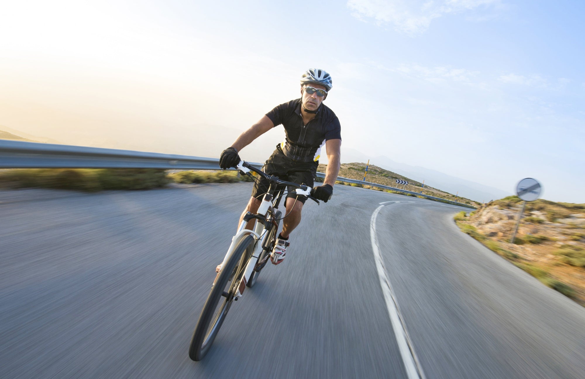 5 Skincare Essentials Every Fit Guy Needs. Handsome fit man cycling towards camera on a sunny day