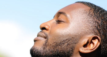 Hyperpigmentation in Men: What Actually Works. Close up side view of handsome black man with glowing clear skin