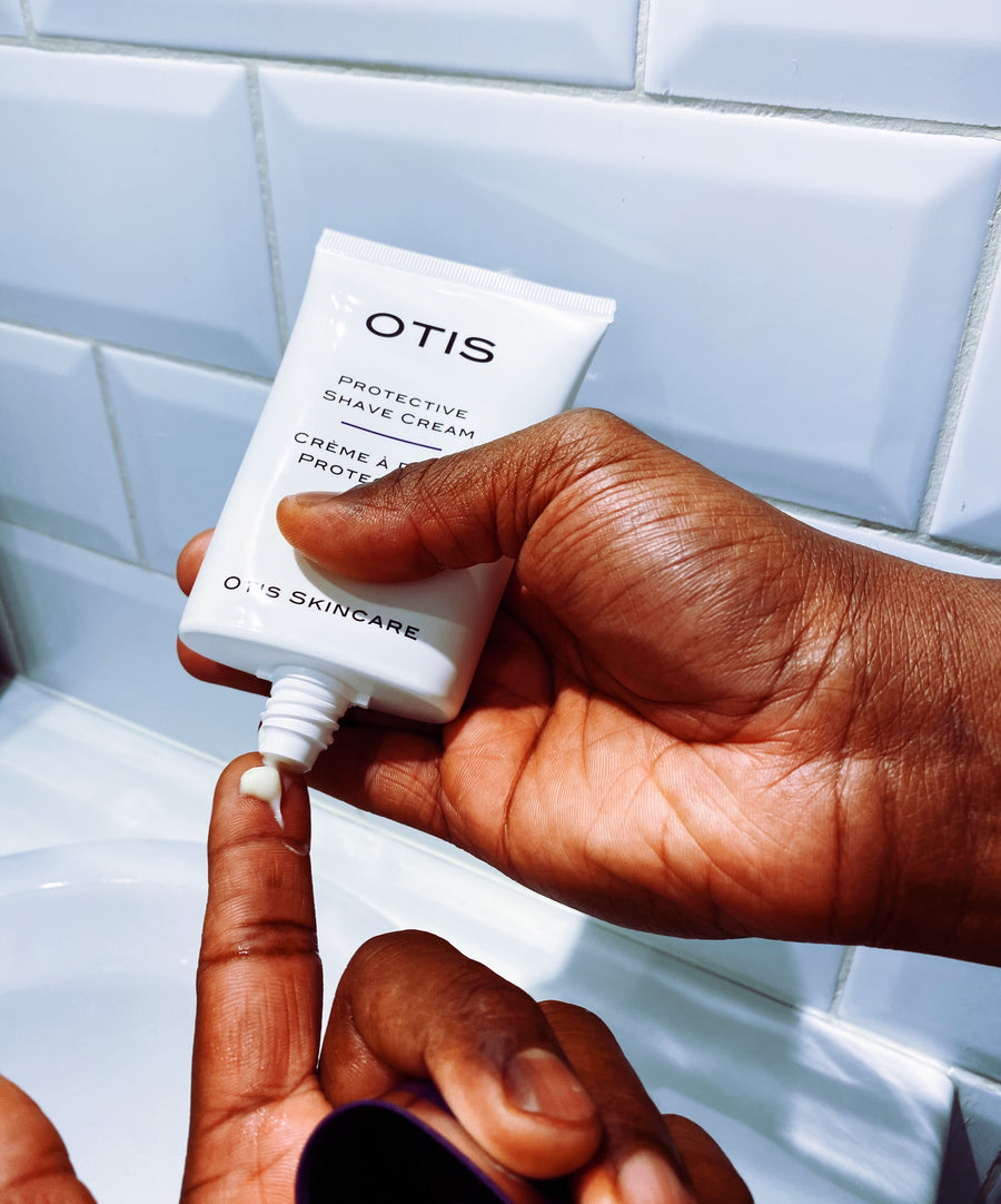 Close up of Black man squeezing a Tube of OTIS Protective Shave Cream onto finger